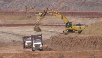 Empty containers on haul trucks are being loaded with mill tailings. Empty containers on haul trucks are being loaded with mill tailings.