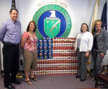 Pictured from left to right in front of the Paducah siteâs American Flag display are Mark Duff (LATA Environmental Services of Kentucky, LLC), Christa Dailey (Pro2Serve), Jennifer Woodard (EM Site Lead), and Kelly Layne (LATA KY). Pictured from left to right in front of the Paducah siteâs American Flag display are Mark Duff (LATA Environmental Services of Kentucky, LLC), Christa Dailey (Pro2Serve), Jennifer Woodard (EM Site Lead), and Kelly Layne (LATA KY).