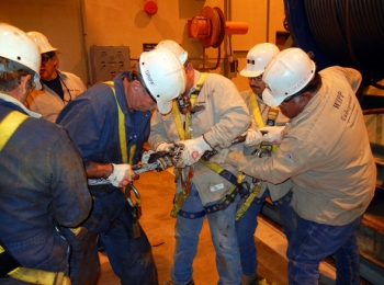 The WIPP shaft crew installs rigging onto a new 2,300-foot-long head rope on the first floor. The WIPP shaft crew installs rigging onto a new 2,300-foot-long head rope on the first floor.
