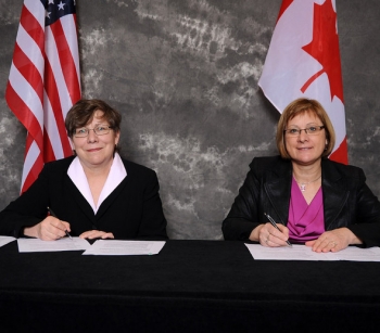 Alice Williams of EM, left, and Joan Miller of the Atomic Energy of Canada Limited, sign a Statement of Intent (SOI). Alice Williams of EM, left, and Joan Miller of the Atomic Energy of Canada Limited, sign a Statement of Intent (SOI).