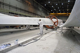 Blades manufactured at Gamesa's factory in Ebensburg, Pennsylvania await delivery for development of wind farms across the United States. Photo courtesy of NREL Library, Gamesa. Photo of wind turbine blades being manufactured.