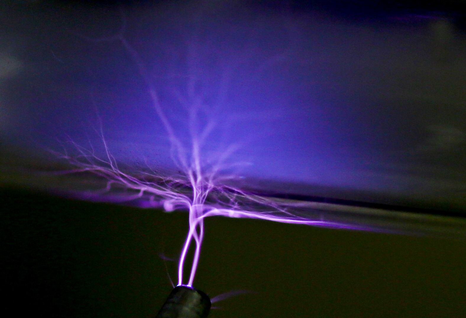 A Tesla coil shown as an electric current is used to test the vacuum in an experimental apparatus