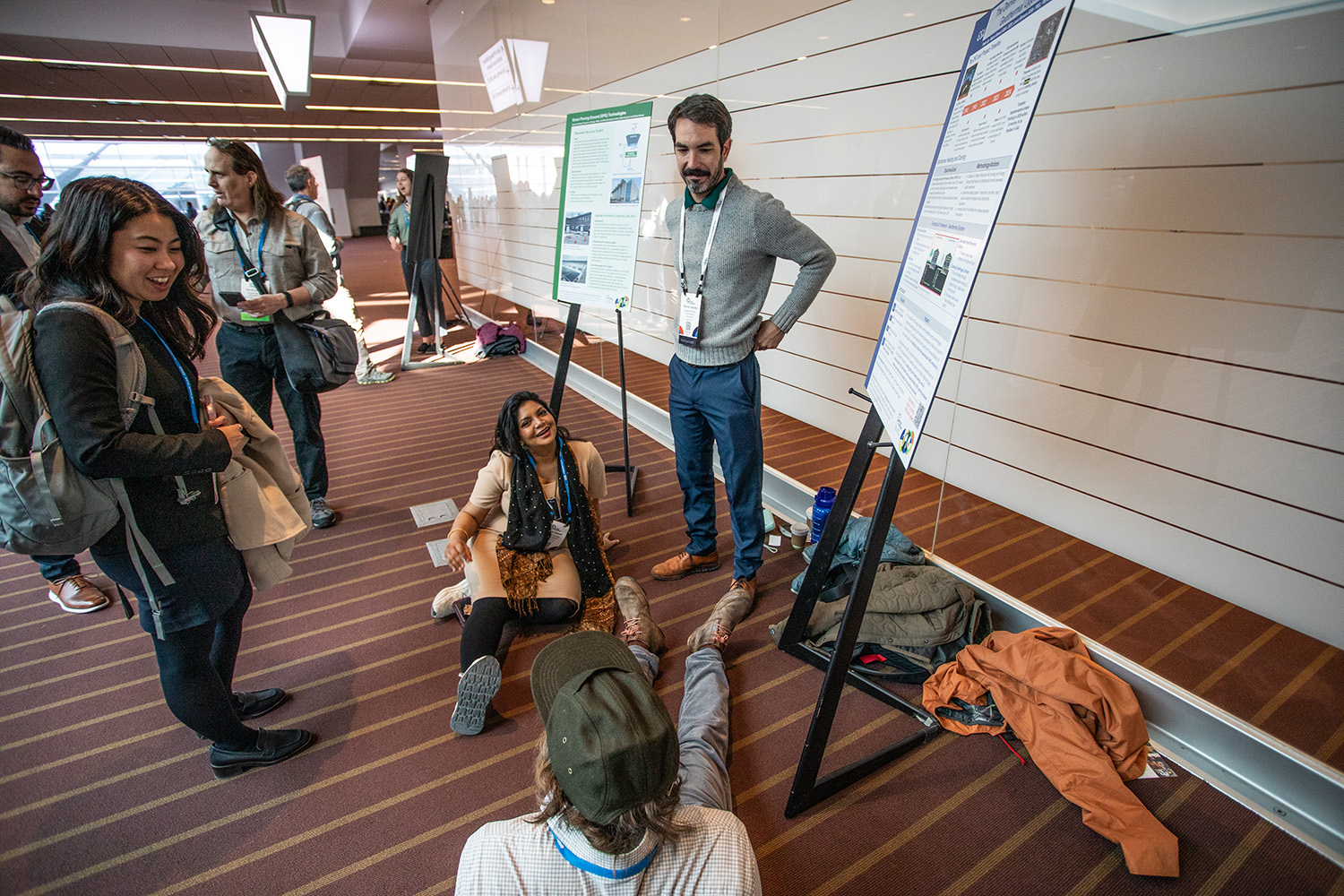 A group of people hanging out by large poster presentations.