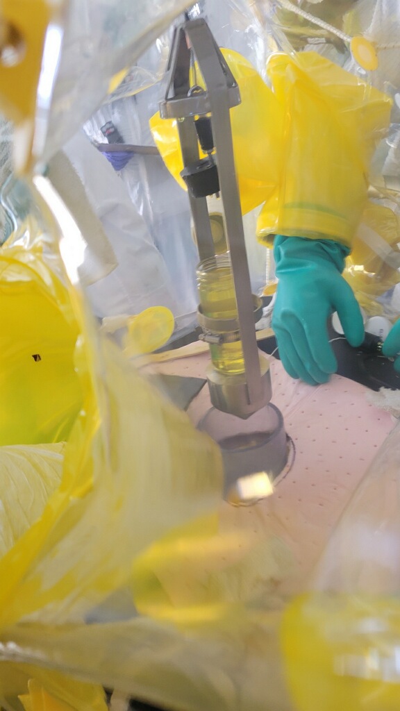 An up-close shot of a sample of liquid inside a glovebox