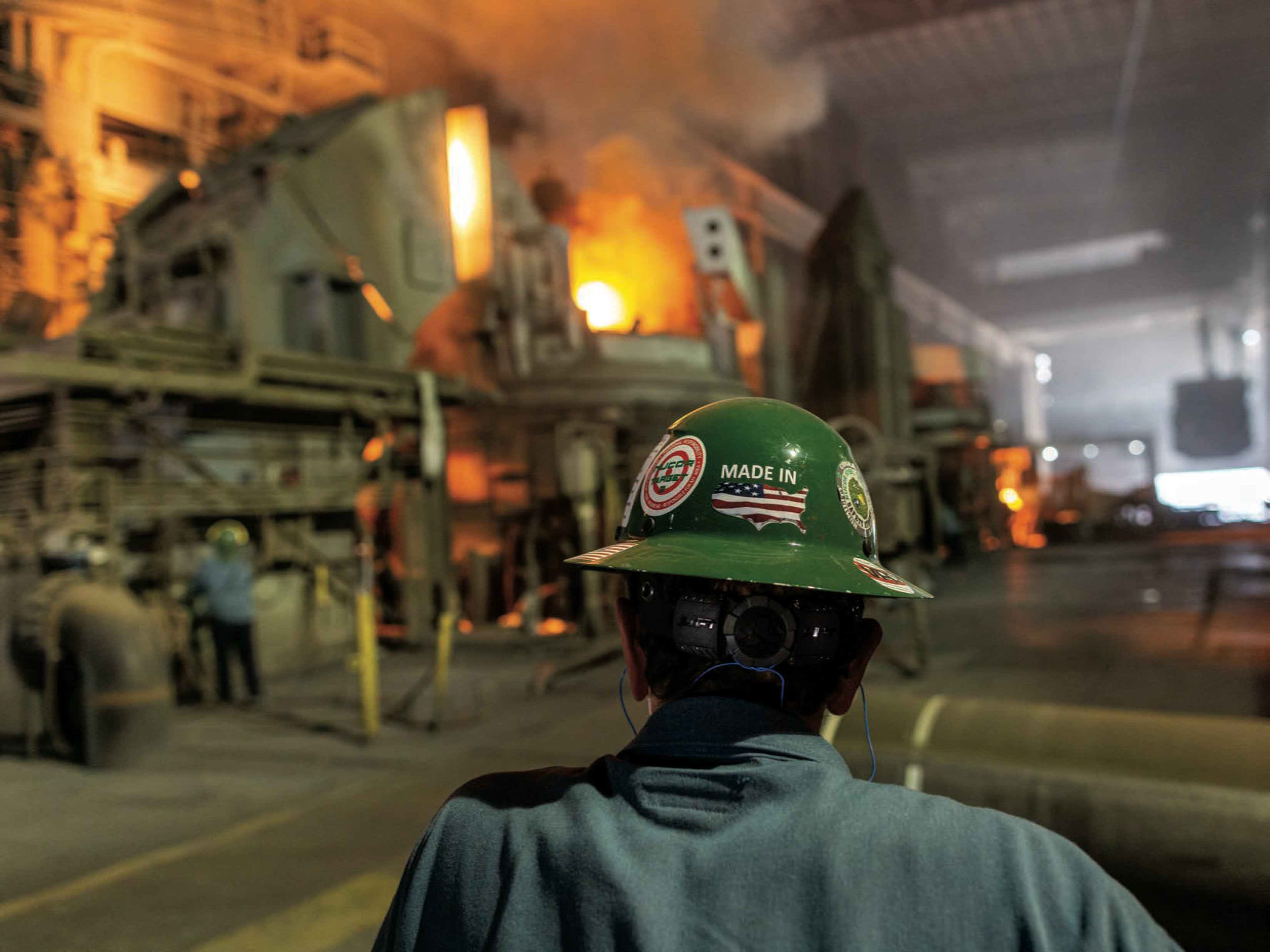 A man in a hard hat looks at an industrial furnace