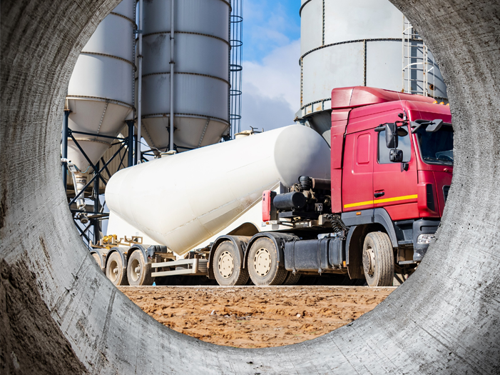 Looking at a cement mixer through a cement pipe