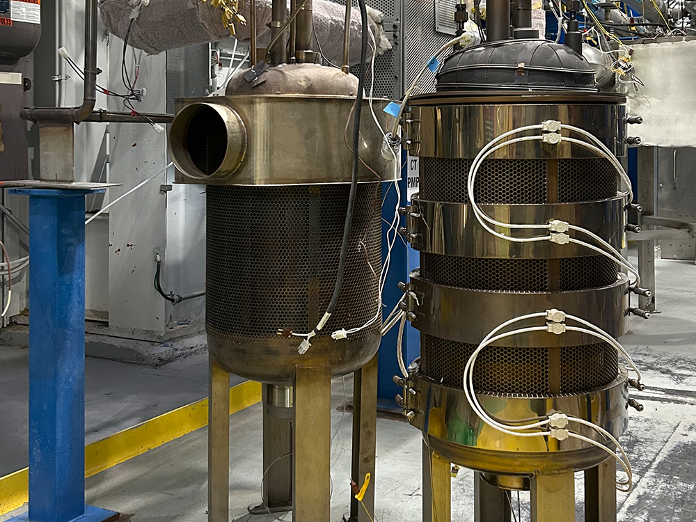 Two cylindrical metal "cold traps" side by side in a laboratory.