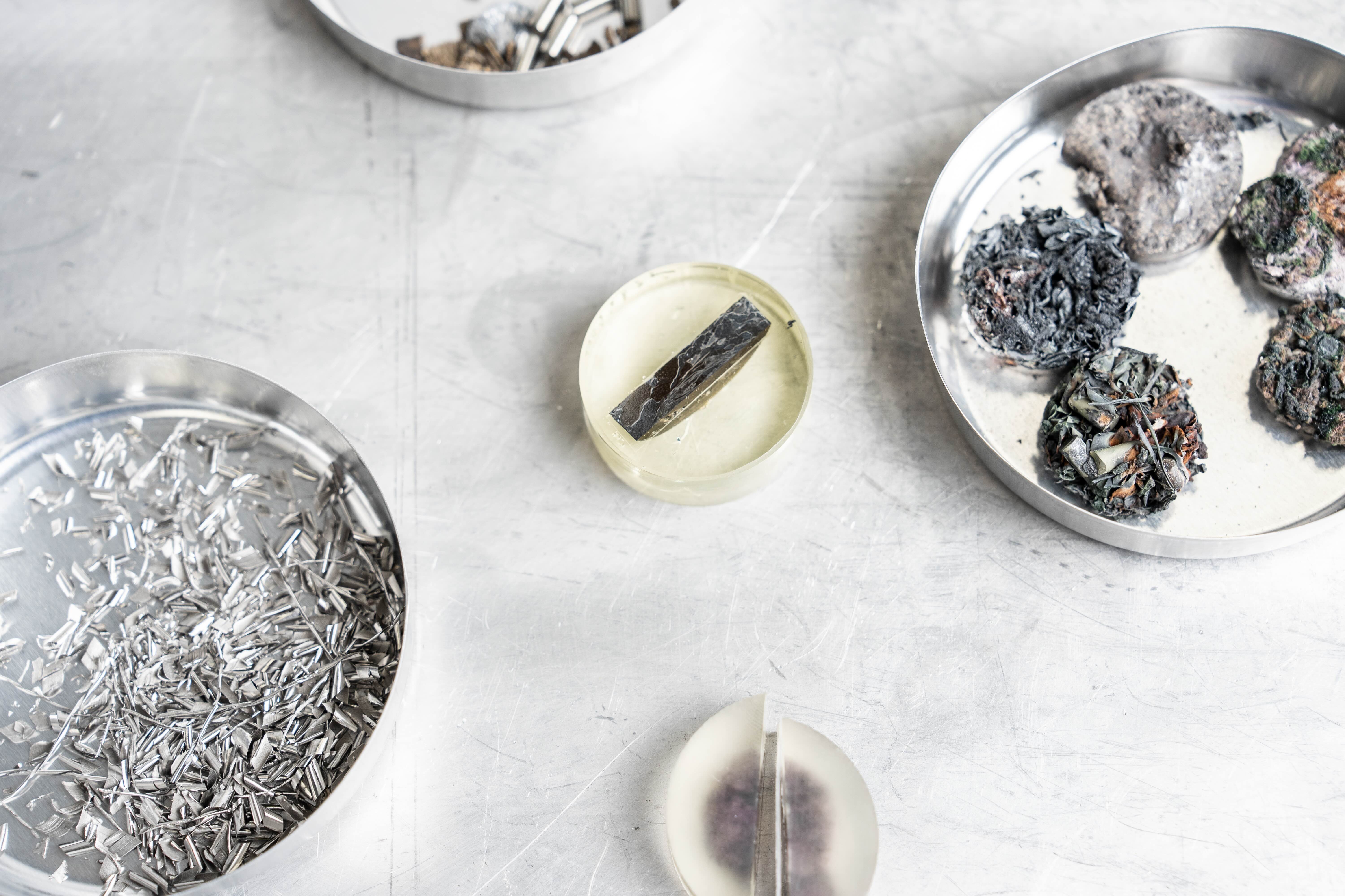 close-up of silver and gray alloys in round petri dishes