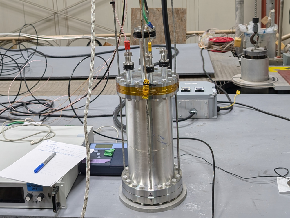 Metal cylinder connected to wires, tubes and other laboratory equipment