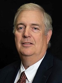 A headshop photo of a person wearing a suit.