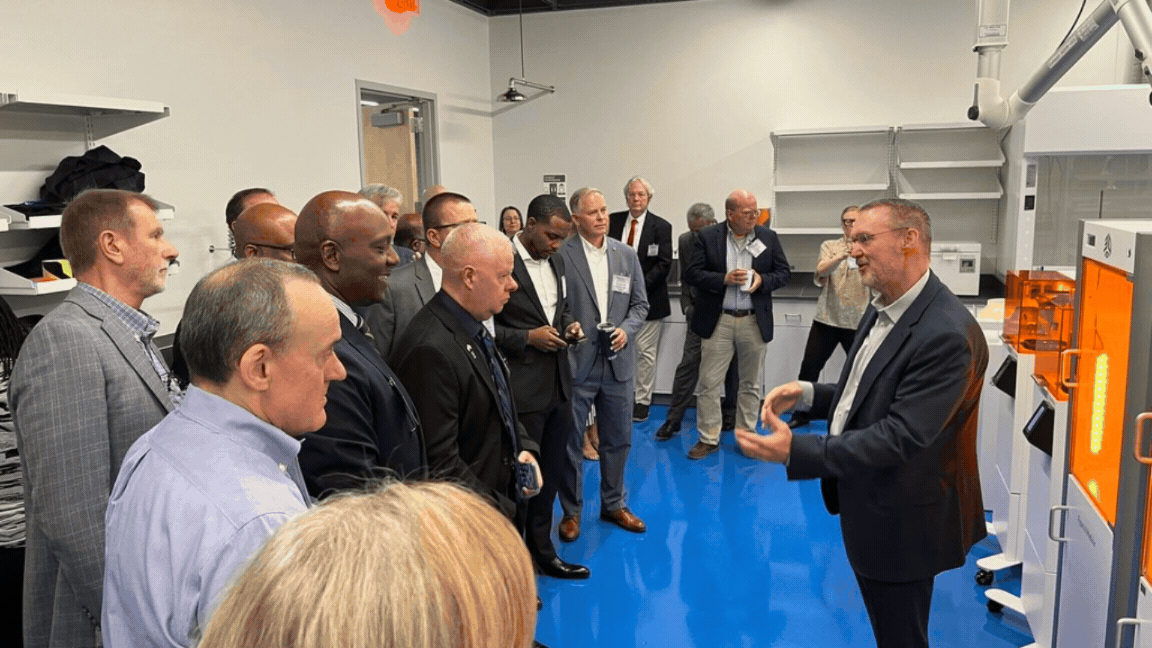 Rotating set of images of a group of professionals touring the Advanced Manufacturing Collaborative building  
