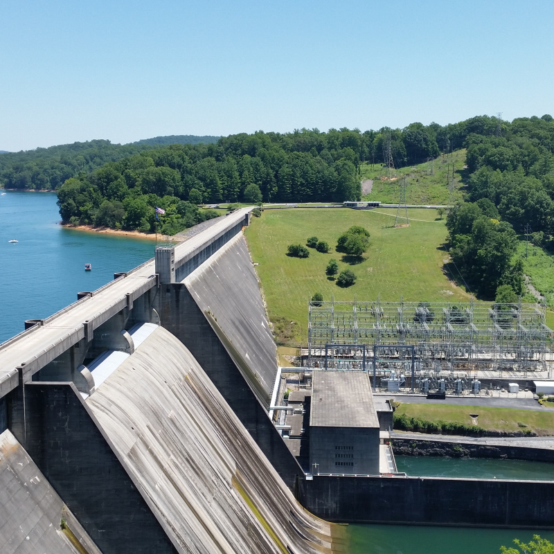 A hydropower dam among grassy fields and trees