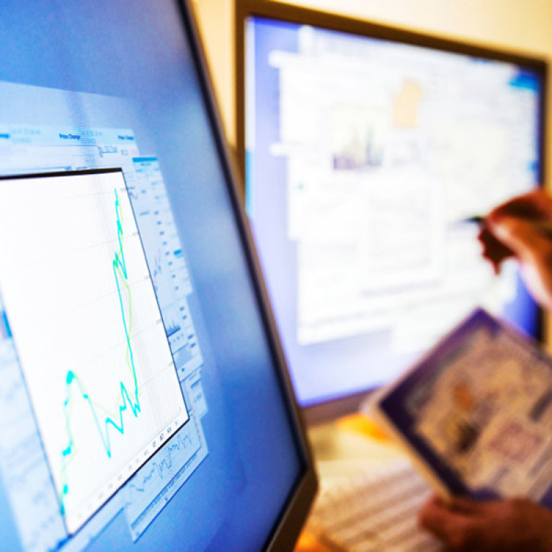 Two hands pointing at computer screens.