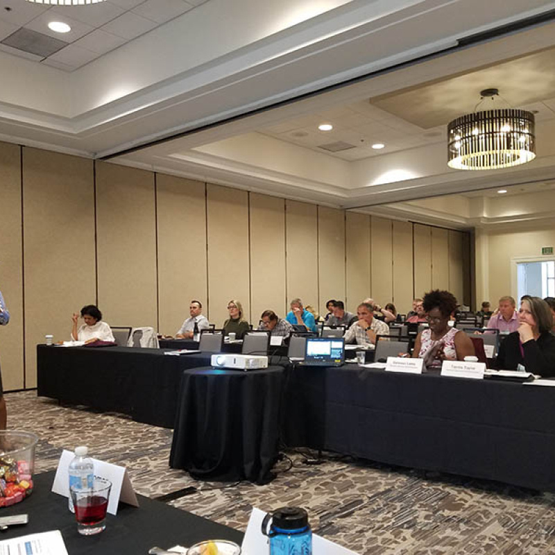 Speaker at the front of a room presenter to the FUPWG audience.