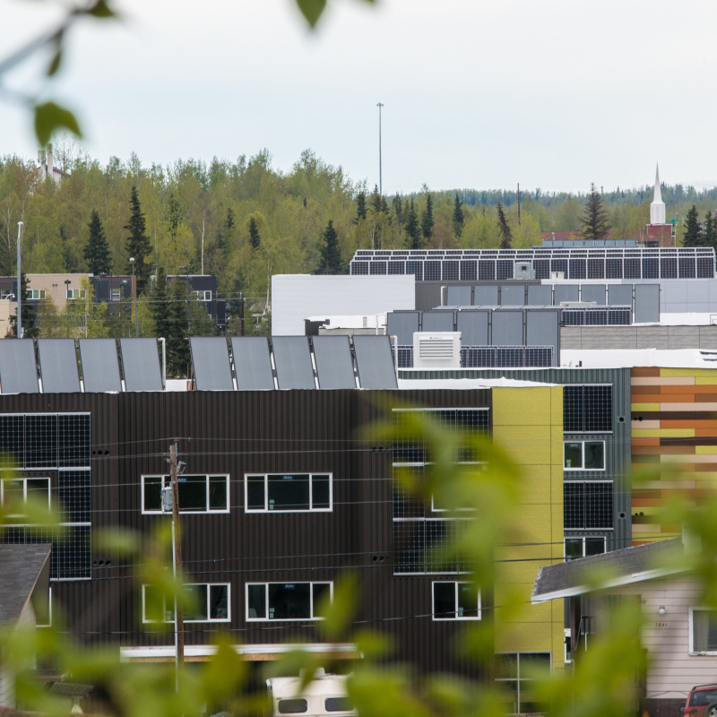 A photo of several buildings in an urban area with solar panels on the roofs