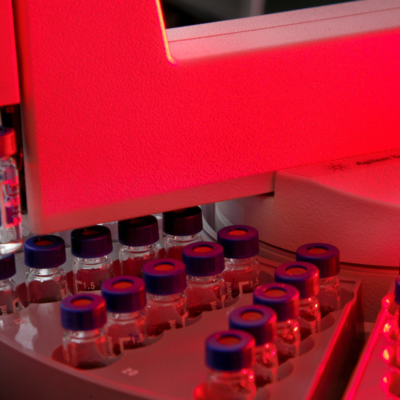 An auto sampler machine moves glass bottles through a gas chromatograph mass spectrometer