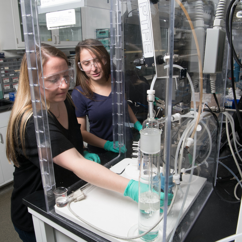 A scientist and engineer at the National Renewable Energy Laboratory collaborate as they test an electrochemical CO2 reduction cell