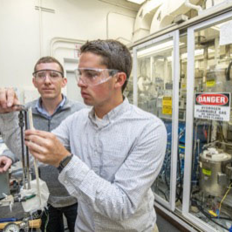 Ian Robinson working in a lab as his mentor watches