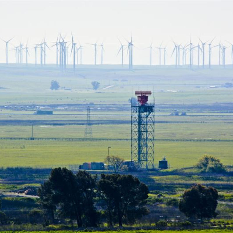 Wind turbines and a radar tower. 