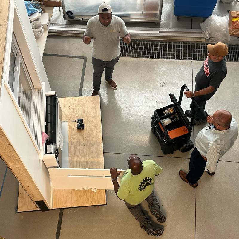 Overhead shot of men working on a window panel.