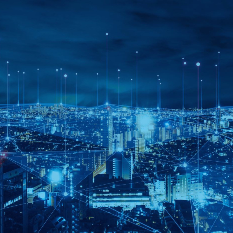 An image of an electrical grid overlaid against a cityscape at night.