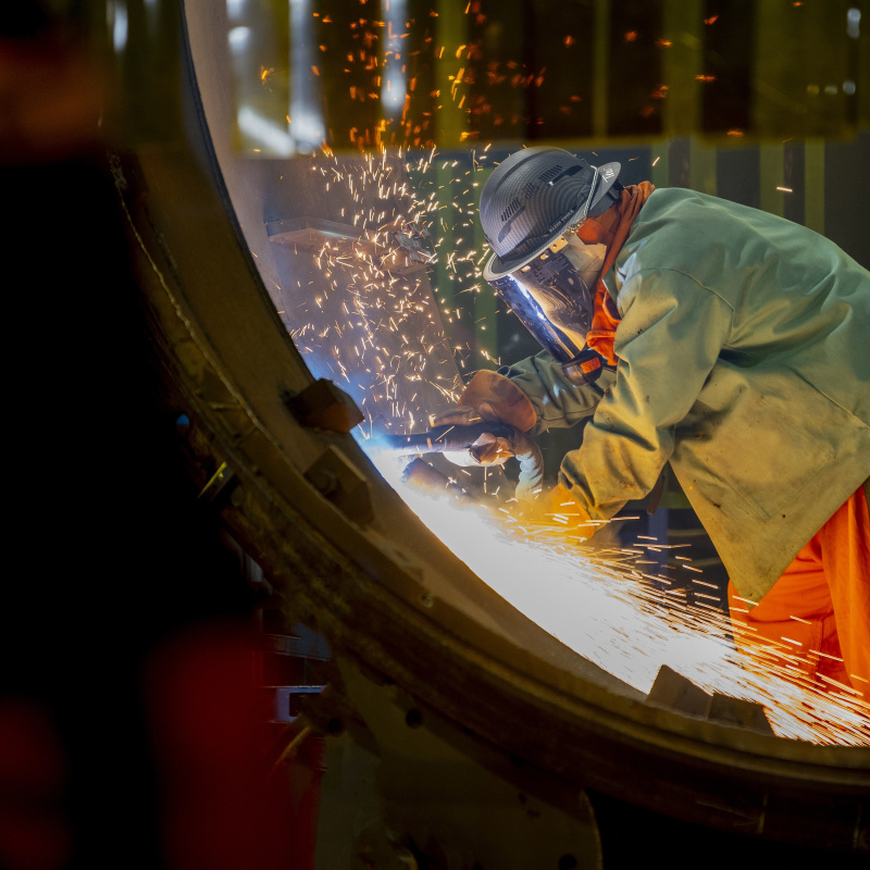 Sparks flying as a person uses a tool on a metal pipe. 