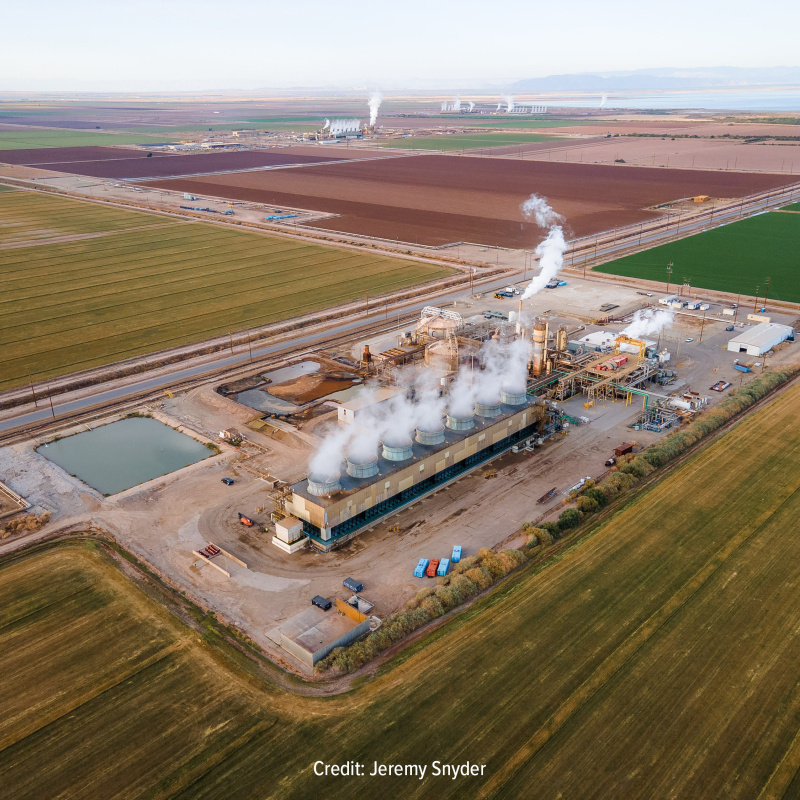 Geothermal power plant in the middle of yellow, brown, and green agricultural fields