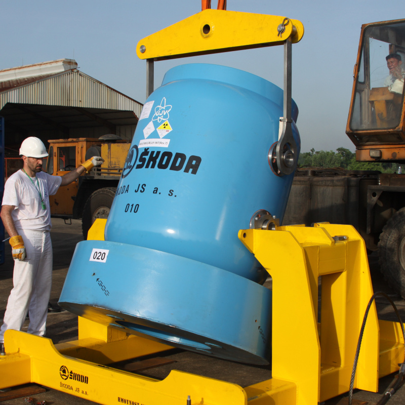 Large blue container and a technician in a white hard hat in Vietnam for an HEU removal