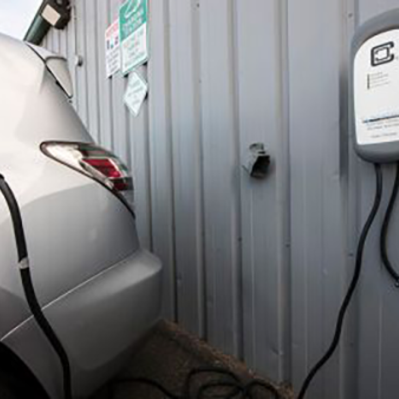 Electric vehicle parked and charging at a charging station