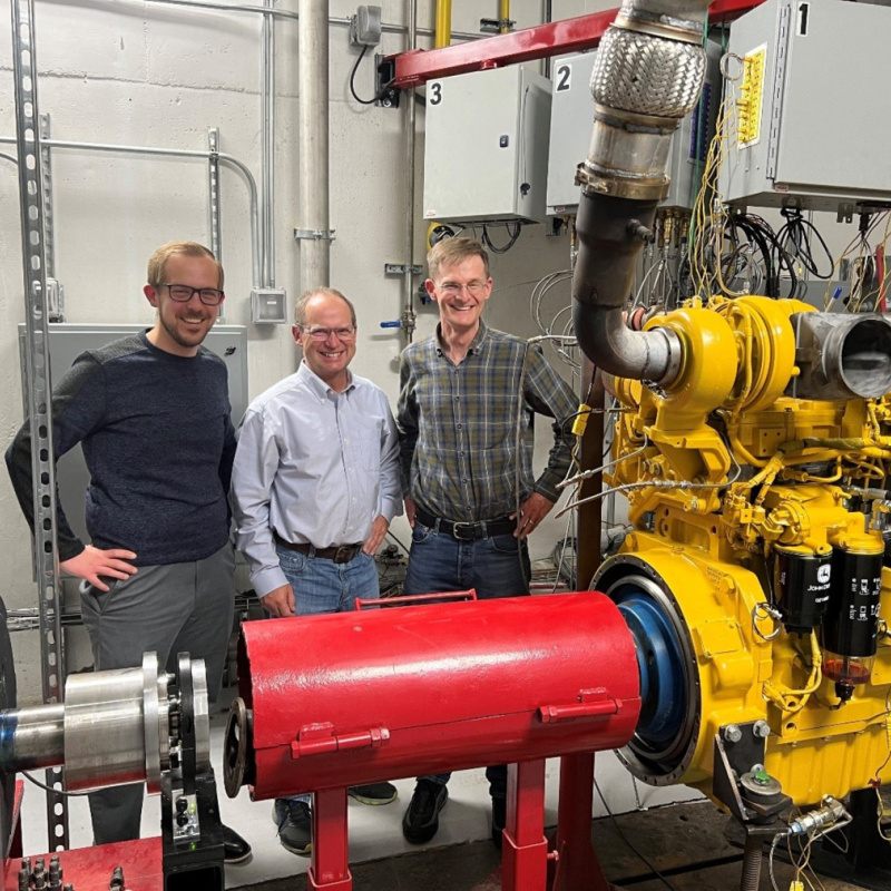  The DFI team smiles in a test cell with John Deere 6-cylinder, 9-liter DFI engine.