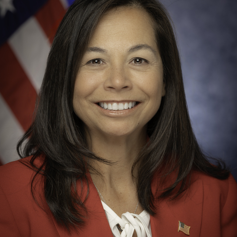 Head and shoulders shot of Catherine Jereza with the American flag in the background.
