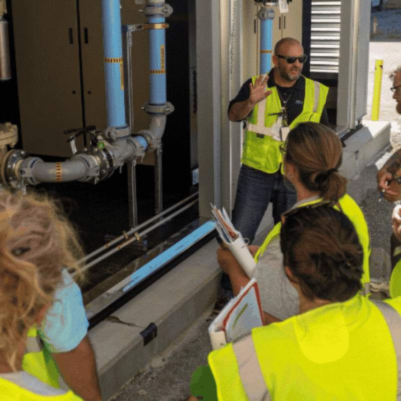 Rotating set of images of a group of teachers wearing yellow safety vests touring the Paducah Site with employees