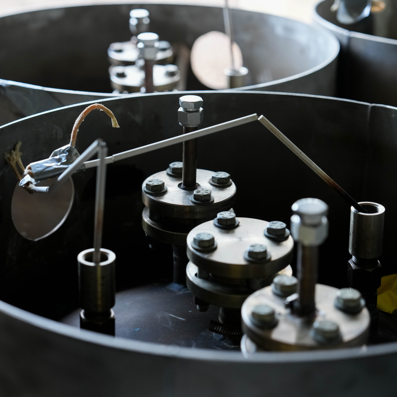 Close-up of FLiBe canisters delivered to Natura Resources, black metallic drums with valves on top.