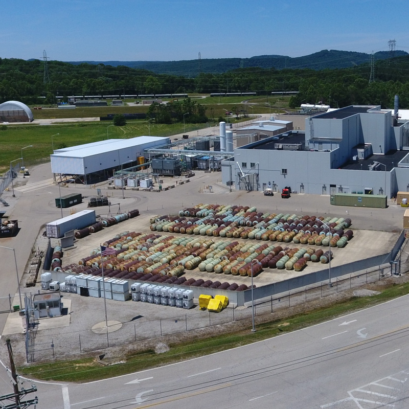 Aerial view of a large facility building with lots of canisters lined up outside of the building