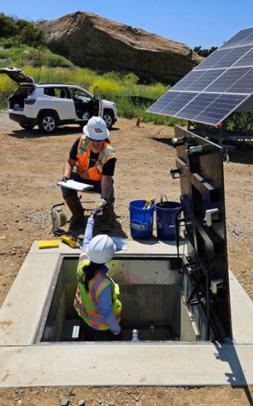 Workers take groundwater samples from a well