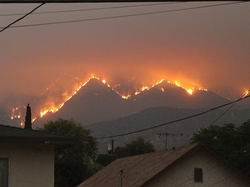 A picture of a hillside on fire in the distance