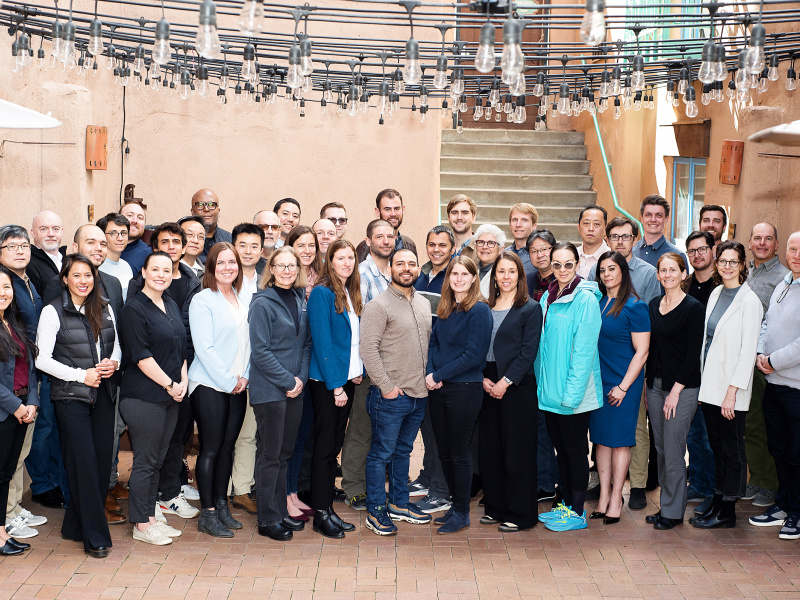 A group of 40 people pose for a photo in an outdoor patio.