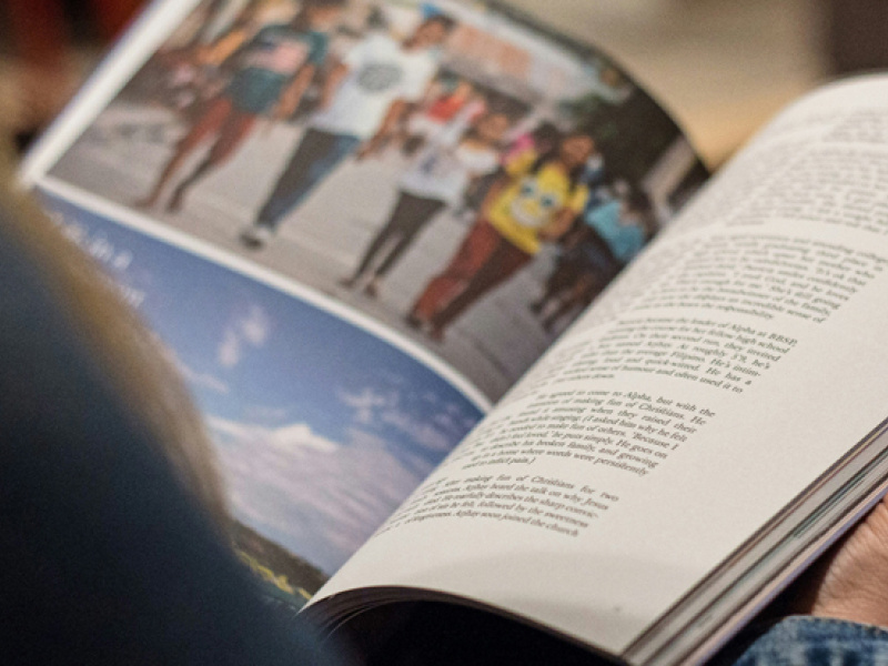 A person looking at a printed magazine