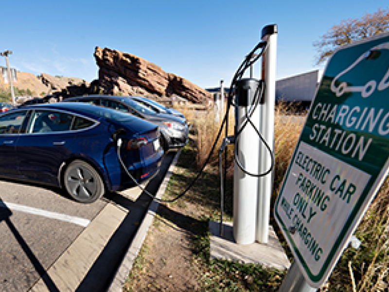 Electric vehicle parked and charging at a charging station in the Red Rocks Park in Colorado.