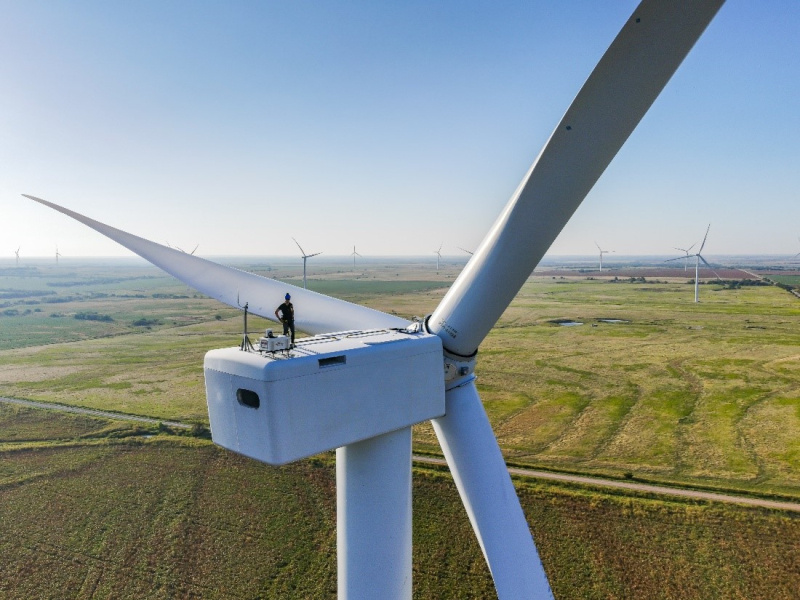 A researcher on top of a wind turbine