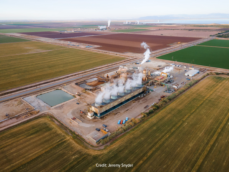Geothermal power plant in the middle of yellow, brown, and green agricultural fields