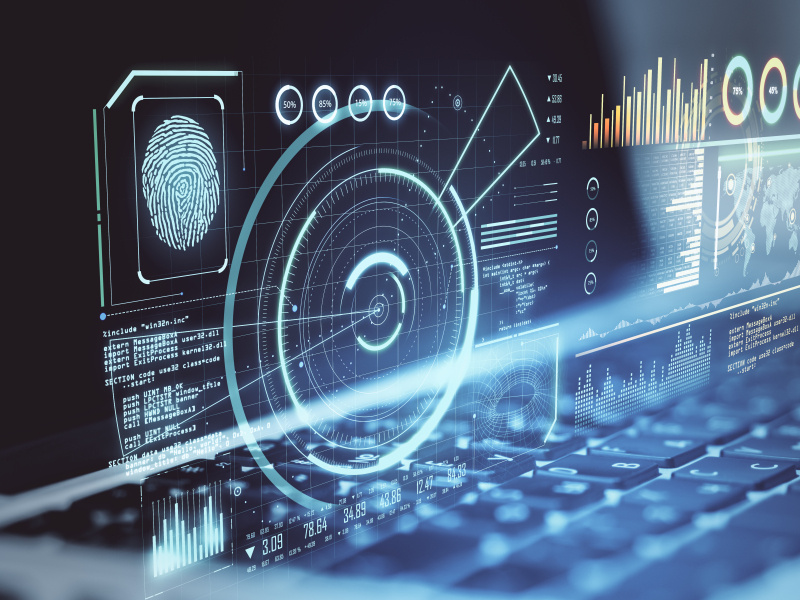 Computer screen of charts and graphs above a keyboard