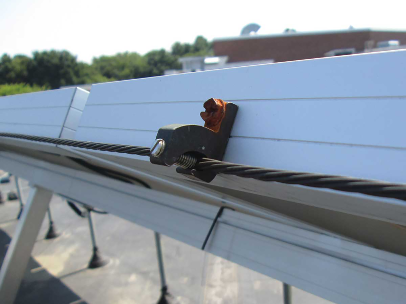 A corroded ground screen in a steel solar PV frame