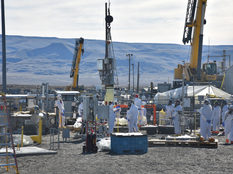 Hanford works removing part of a pump outside at a work site