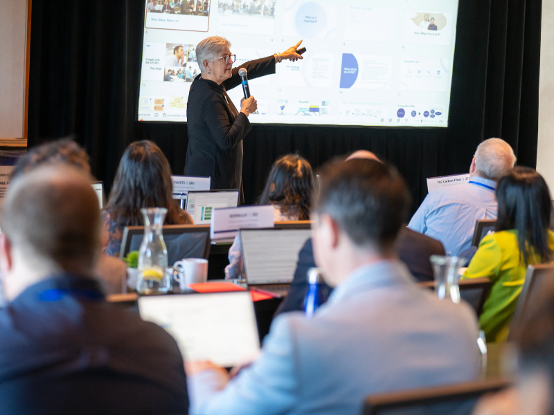Woman delivers presentation to large group