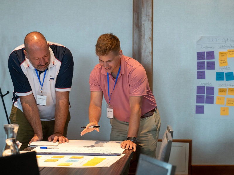 Two people collaborate and review meeting notes