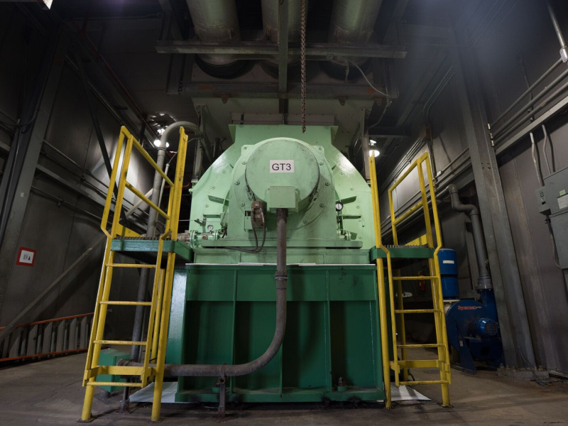 Large green power generation equipment labeled GT3 inside the Cambalache Power Plant, surrounded by yellow access ladders, pipes, and industrial infrastructure.