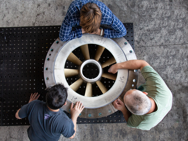 Hydropower researchers gathers around the turbine