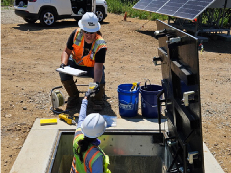 Workers take groundwater samples from a well
