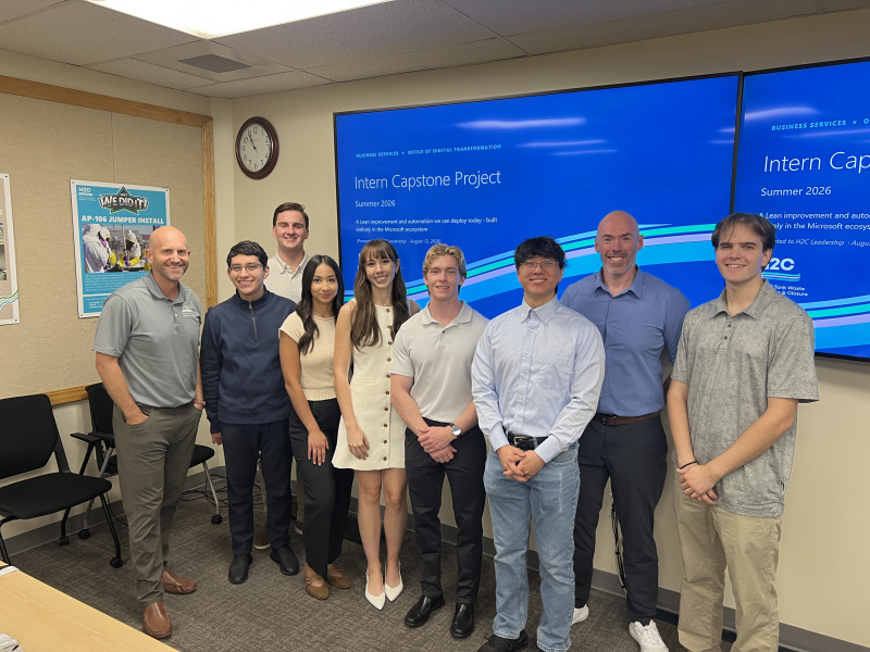 A group of interns posing for a photo in a classroom